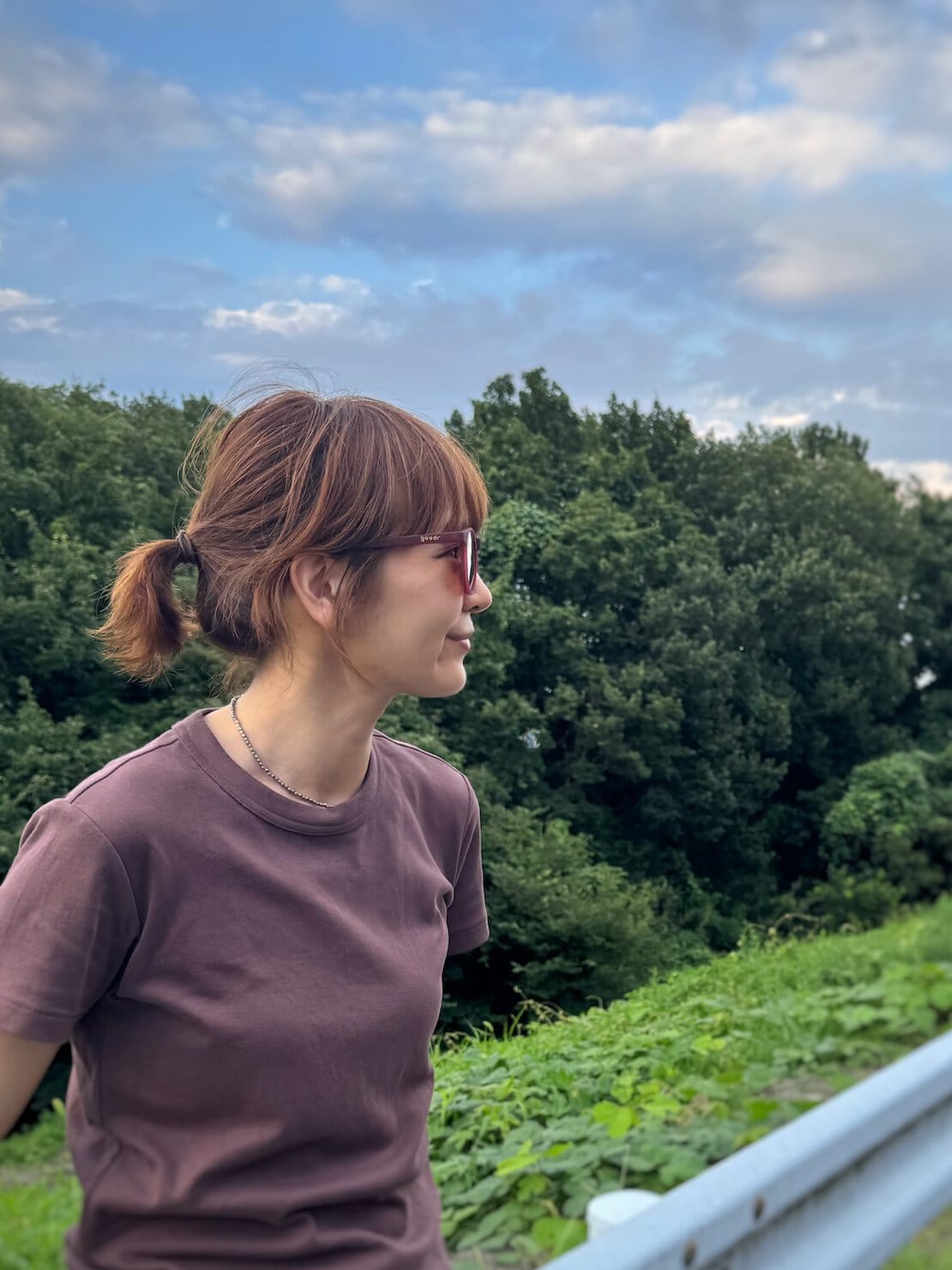 サングラスを掛けた横顔写真。ブラウンのTシャツを着て。