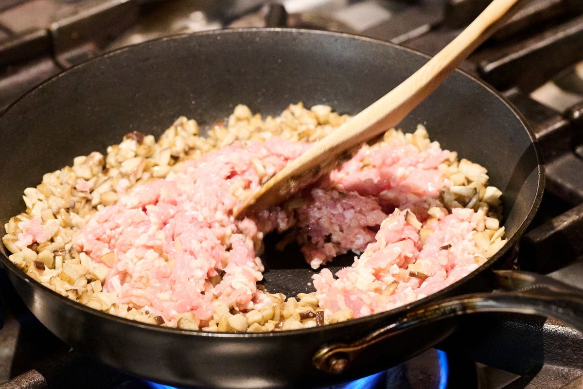 ひき肉を入れて炒めてる様子