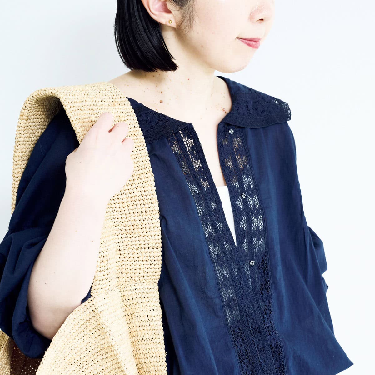 襟と前立てにあしらわれた繊細なレースが、落ち着いたトーンのなかに上品な華やかさを添えています。