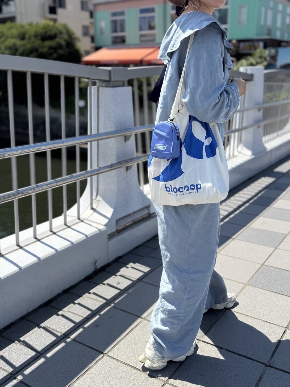 ブルーのリネンサロペットに布バックを肩掛け、リンネル9月号増刊付録のミッフィーコラボミニリュックポーチをつけて。
