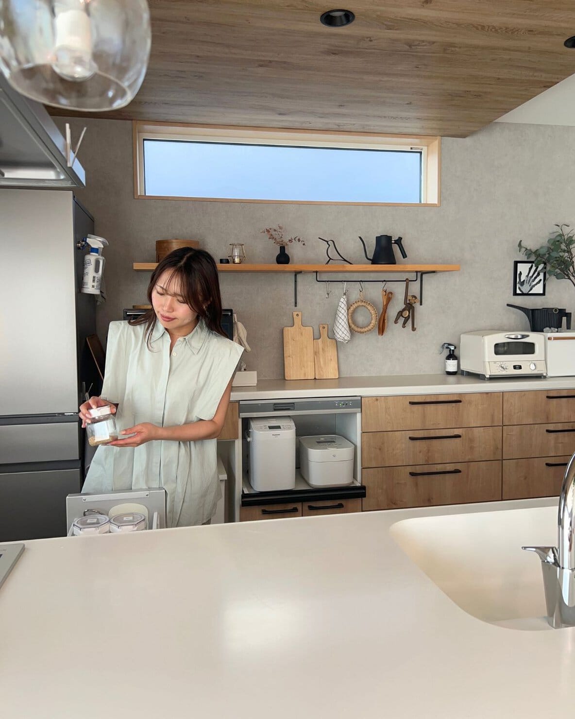 北欧モダンインテリアのキッチンで片付けをしている二児の母