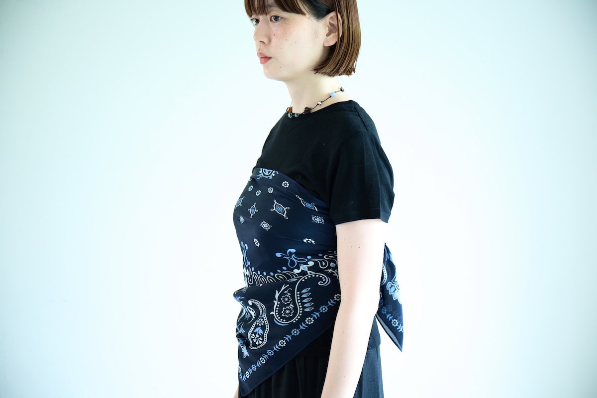 黒のTシャツにローリーズファームのバンダナ柄スカーフを巻き、カラフルなビーズネックレスを合わせた上半身