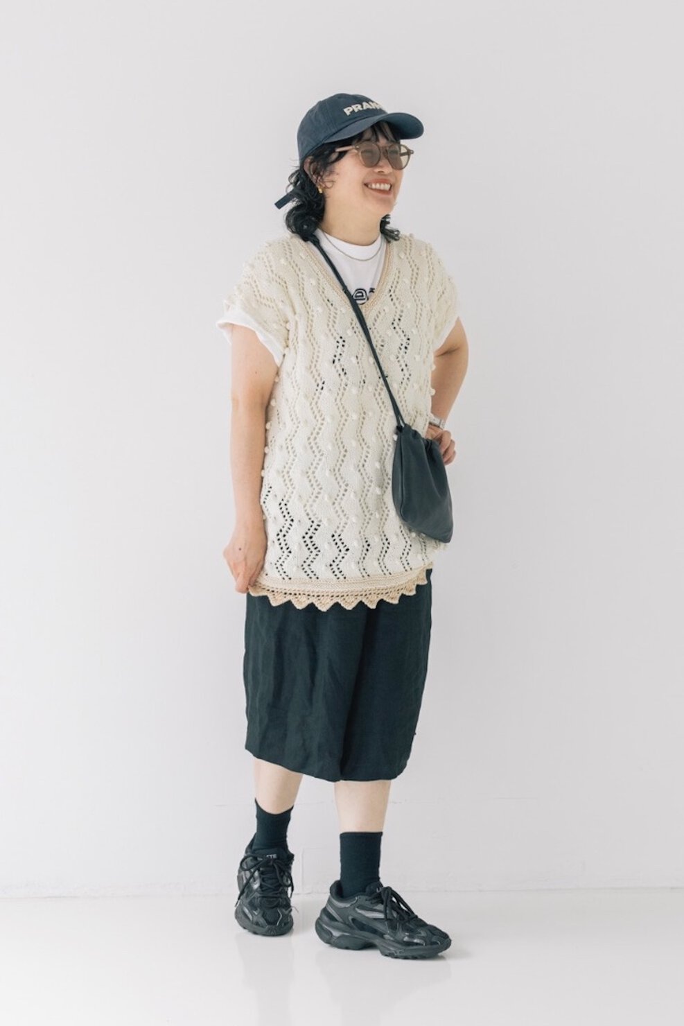ヘアメイクデザイナー 高松由佳さんの私服ファッションスナップ。メンズライクなハーフパンツスタイルは、透かし編みニットでやわらかく